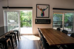 Spa and Lakefront - Oasis des chutes في Lac-Saint-Paul: غرفة طعام مع طاولة وكراسي خشبية +35 صورة