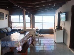 a living room with a couch and a large window at Casa de frente ao mar Enseada de Brito in Enseada do Brito