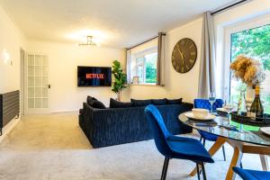 a living room with a blue couch and a table at The Cove in Solihull