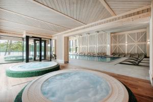 two large tubs in a room with a pool at Aries Lago Park Hotel & SPA, Mazury in Olsztynek
