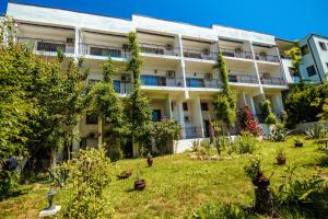 an apartment building with a garden in front of it at MIOARA Rooms parter in Venus