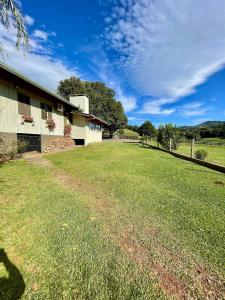 a large grass field next to a building at Rancho Áustria - Hospedagem Exclusiva in Treze Tílias