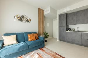 a living room with a blue couch and a kitchen at Binda 21-2F charme moderno Navigli - Vesta in Milan