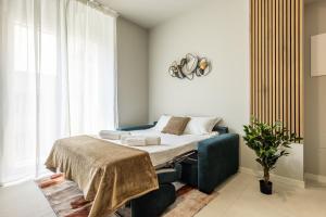 a bedroom with a bed and a blue couch at Binda 21-2F charme moderno Navigli - Vesta in Milan