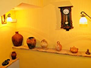 a bunch of vases sitting on a shelf with a clock at Casa Mairal in Salillas