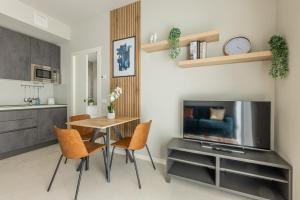 a living room with a table and chairs and a television at Binda 21-2F charme moderno Navigli - Vesta in Milan +17 photos