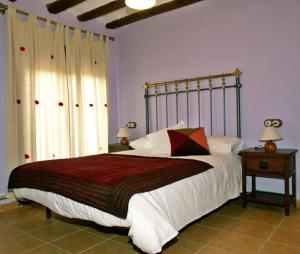 sypialnia z dużym łóżkiem z metalową ramą w obiekcie Casa Mairal w mieście Salillas