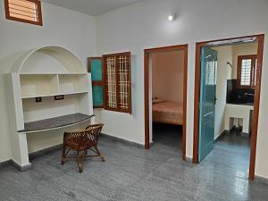 a room with a chair and a room with a bed at Green house in Tiruvannāmalai