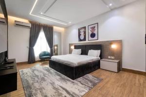 1 dormitorio con 1 cama, TV y alfombra en Exclusive 3 Bedroom apartments with pool and high grade amenities, en Lagos