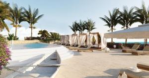 a resort with a pool and chairs and palm trees at Luxury resort in Jericoacoara