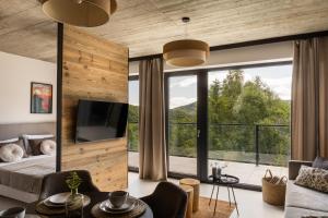 a bedroom with a large window and a bed with a television at WIDOQ Resort Szczyrk in Szczyrk