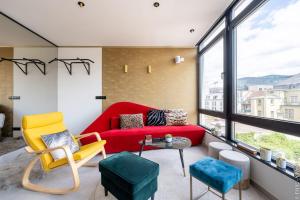 a living room with a red couch and yellow chairs at Ecstatic Living Ixelles, Luxury in the European Quarter in Brussels