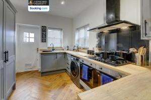a kitchen with a washer and dryer in it at Large 6BDR House By Homebird Property Management Short Lets & Serviced Accommodation Leeds With Secured Parking & Garden Area in Leeds +14 photos