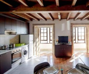 una grande cucina con piano cottura e lavastoviglie di APTOS SOLAINA O PINDO a O Pindo