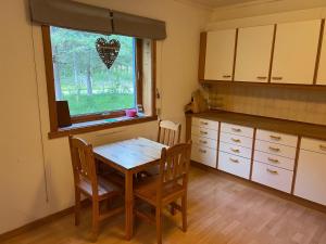 a kitchen with a table and chairs and a window at Hytte Elvdal in Nymoen