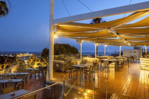 a restaurant with tables and chairs on a deck at night at St Raphael Resort & Marina in Limassol