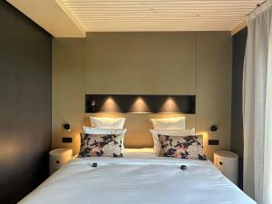 a bedroom with a bed with white sheets and pillows at James Vignoble Hôtel, Eguisheim in Eguisheim
