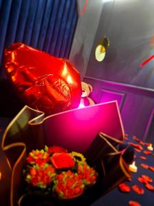 a box filled with flowers next to a table at Love Room 85 avec Jacuzzi & Terrasse Privé in Kortrijk