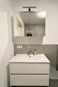 a bathroom with a white sink and a mirror at The Sapphire Suite in Luxembourg