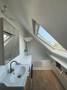 Un baño con lavabo y ventana. en Duplex vue mer à Rochebonne Plage Parking, en Saint-Malo