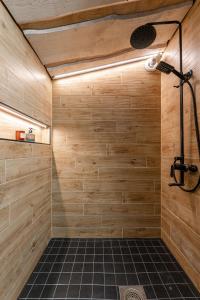 a bathroom with a shower with a black tile floor at Himosranta Suite A - Private Suite with Hot Tub & Lake Views in Jämsä