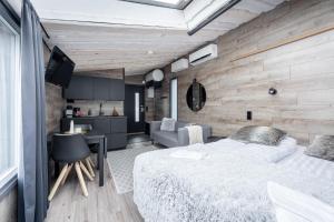 a bedroom with a large bed and a kitchen at Himosranta Suite A - Private Suite with Hot Tub & Lake Views in Jämsä