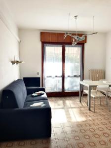 a living room with a couch and a table at Condominio Tirrenia 5 in Lignano Sabbiadoro