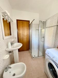 a bathroom with a sink and a washing machine at Condominio Tirrenia 5 in Lignano Sabbiadoro