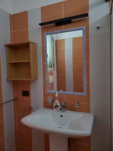 a bathroom with a white sink and a mirror at Villa Elvis in Orikum