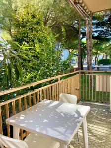 a white table and chairs on a wooden deck at Condominio Tirrenia 5 in Lignano Sabbiadoro