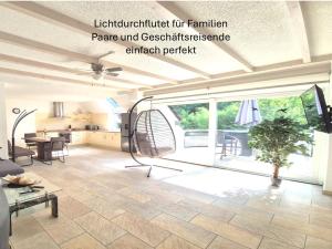 sala de estar con ventana grande y mesa en Stilvoll am Wald wohnen 115 qm Office citynah, en Stockstadt am Main