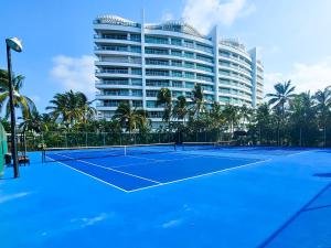 a tennis court in front of a large building at Departamento Mayan Lakes T11 - Albercas, club de playa, tenis, pádel y más in Acapulco