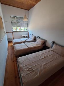 3 lits sont disposés dans une chambre avec une fenêtre. dans l'établissement Casas Chris Cavadas, 