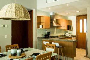 a kitchen with a table and chairs in a kitchen at Departamento Mayan Lakes T11 - Albercas, club de playa, tenis, pádel y más in Acapulco