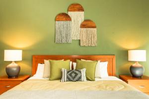 a bedroom with a bed with two lamps and two mirrors at Departamento Mayan Lakes T11 - Albercas, club de playa, tenis, pádel y más in Acapulco +64 photos