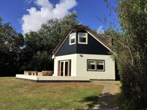 una piccola casa bianca con tetto nero di Mansion in De Cocksdorp a De Cocksdorp