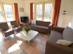 un soggiorno con un divano, sedie e un tavolo di Mansion in De Cocksdorp a De Cocksdorp Altre 16 foto