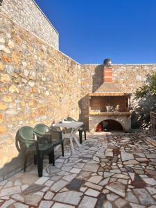 a patio with a table and chairs and a fireplace at Grandpa's Chill House in Oitylo