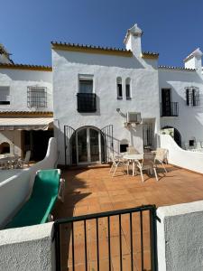 a patio with a table and chairs in front of a building at Lamedos in San Luis de Sabinillas