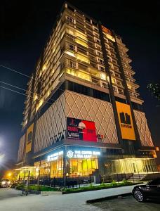 a tall building at night with lights at Elysium Prestige Pent House City View Islamabad in Islamabad