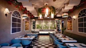 a restaurant with tables and blue chairs and a window at Narayan Kothi in Varanasi