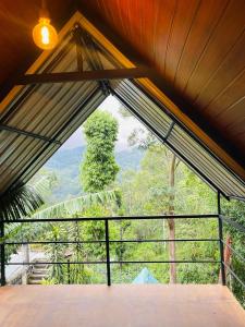 a room with a window with a view of the forest at Fair View Cottage in Ella