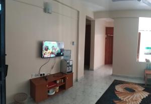 a living room with a flat screen tv on a wall at N&G Blessed Pioneer Holiday Homes in Mombasa