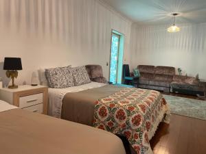 a bedroom with two beds and a couch at City World Apartment in Maia +3 photos