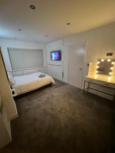 a bedroom with a bed and a television in it at Luxeliving The Larch Residence in High Hazels