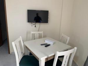 a white table and chairs with a television on a wall at الف ليله و ليله اكوا بارك بورسعيد in Port Said
