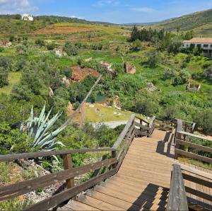 a wooden boardwalk with a view of a hill at Casa da Travessa in Alte
