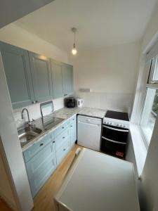 a kitchen with blue cabinets and a sink at Beckington House in Braunton +4 photos