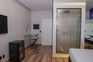 a bedroom with a bed and a desk and a sliding glass door at STILLUS MOTEL - Suítes Privativas Confortáveis em Imperatriz in Imperatriz +44 photos