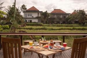 a wooden table with food on top of a balcony at Artropeace Ubud Retreat & Villas in Ubud